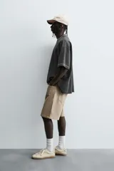 Camiseta color beige de corte holgado, cuello redondo y manga corta.