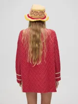 Sweater color crema con tejido en ochos, cuello redondo, puños acanalados con doble raya azul y tajos a los costados.
