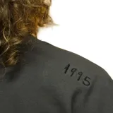 Remera gris oscuro de manga corta con cuello redondo y logo bordado en el pecho.