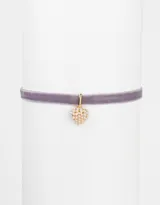 Gargantilla tipo choker de terciopelo color lila con dije de corazón dorado cubierto de perlas.