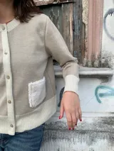 Cardigan tejido en lana Merino color tostado, con botones frontales y diseño decorativo en el pecho.