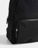 Mochila negra de tela deportiva con bolsillo frontal con cierre, correas regulables, manija superior, cierre superior y tag de goma.