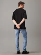 Pantalón de jean celeste de corte slim tapered, con talle medio, pierna estrecha y bragueta con cremallera. Confeccionado con 20% de algodón reciclado.