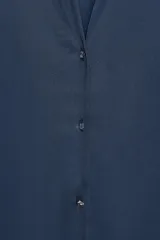 Camisa azul marino de satén con cuello solapa, escote en pico y mangas largas con puños abotonados.