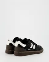Championes urbanos Coolway modelo Goal, color negro con detalles en blanco y marrón. Confeccionados en cuero suave con puntera reforzada, cordones planos de algodón bicolor intercambiables y suela flexible de goma y caucho.