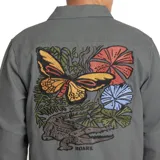 Campera gris de algodón canvas, estilo camisa, con bordado de un sol en el bolsillo del pecho. Tiene dos bolsillos con solapa en el pecho y cierre con botones. Corte recto y holgado.