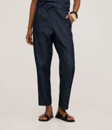 Pantalón de jeans de color azul oscuro, corte carrot (holgado en cadera y afunilado en pierna), con cintura alta ajustable mediante cordón.