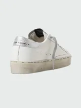 Championes de cuero acordonados en color blanco con suela alta de diseño distintivo.
