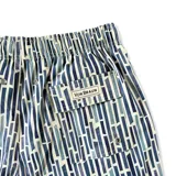 Short de baño azul con estampado de líneas verticales en tonos de azul y blanco. Tiene elástico en la cintura, cordón ajustable, tres bolsillos y mesh interior hipoalergénico.