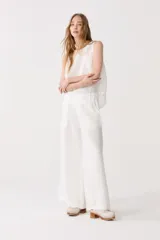 Pantalón blanco de lino con cintura alta, elástica y piernas anchas, ideal para uso cotidiano.