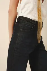Pantalón de jean azul oscuro, de tiro medio y calce ajustado. Pierna acampanada desde la rodilla.