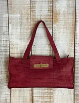 Cartera tote bag color borgoña, con textura tipo piel de cocodrilo, cierre con solapa y herraje dorado.