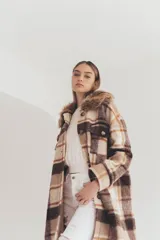 Tapado largo con estampado a cuadros en tonos marrón, beige y blanco. Presenta cuello con solapa y detalle de piel sintética.