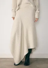 Falda larga color crudo, de tejido de punto acanalado, con cintura elástica y diseño asimétrico.