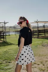 Minifalda pareo blanca con estampado de lunares negros y lazo lateral.