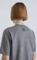 Remera gris melange de algodón premium, manga corta, cuello redondo y calce regular con recorte en la espalda.