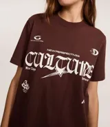Remera marrón de algodón con estampa frontal con la palabra 'Culture' en tipografía gótica y otros textos en blanco. Corte recto y mangas cortas.
