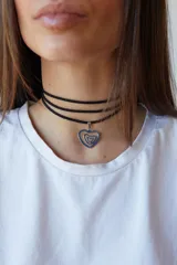 Gargantilla de tiento sintético negro con dije de laberinto con forma de corazón en acero quirúrgico plateado.