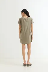 Vestido corto color verde oliva con estampado de dos rostros en color blanco.