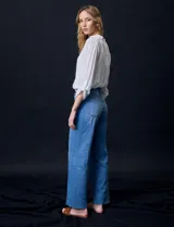 Jean de tiro alto, marca Royalty, color azul. Pretina con pasadores, botón y cierre. Delantera y trasera con bolsillos. Costura lateral asimétrica. Fit Wide Leg.