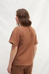 Blusa blanca de lino con escote en V y mangas cortas amplias.