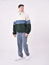 Buzo de polar con cierre a la altura del cuello, diseño a bloques de color blanco, azul y verde.