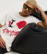 Remera blanca de algodón con cuello redondo y mangas cortas. Estampado frontal con la frase "Yo ❤️ Latino America" en rojo y negro.