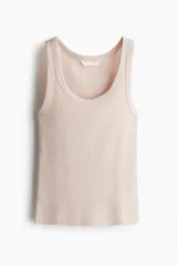 Musculosa color rosa claro, de punto acanalado, con cuello redondo y sisas anchas.
