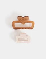 Set de dos broches para el pelo, uno color marrón con forma rectangular y detalle de corazón, y otro color crema con diseño marmolado.