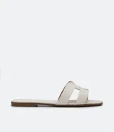 Sandalias planas color crema con puntera cuadrada y tiras anchas en forma de H.