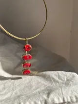 Gargantilla hecha a mano en bronce con piezas de coral rojo, destacando su singularidad en cada collar.