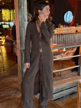 Saco largo de tejido de punto negro, con diseño acordonado en el frente y mangas largas.