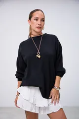 Sweater negro de punto con cuello redondo, mangas largas y corte holgado.