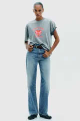 Camiseta rosa de algodón con efecto lavado, corte regular, cuello redondo y mangas cortas. Estampado frontal con la frase "Puerto Rico Vuela Conmigo".