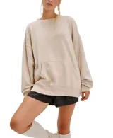 Buzo de tejido afelpado lavado, color beige claro, con cuello redondo y bolsillo canguro frontal. Presenta un calce oversized y relajado.