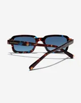 Lentes de sol unisex Hawkers X Pierre Gasly, con montura rectangular de carey con detalles en azul y lentes degradadas en azul.