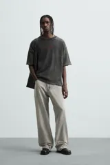 Camiseta negra con efecto lavado, corte boxy fit, cuello redondo y manga corta. Estampado rojo en el frente.