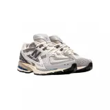 Championes urbanos New Balance modelo U1906NA, color gris y blanco, confeccionados en malla y materiales sintéticos, con logo "N" característico en los laterales y entresuela con tecnología ABZORB y N-ergy.