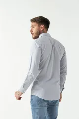 Camisa celeste a cuadros, de corte slim fit, manga larga y logo bordado. Confeccionada en 100% algodón.