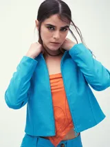 Chaqueta celeste con cierre frontal, cuello clásico y mangas largas.