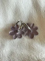 Aros colgantes dorados con forma de flor blanca.