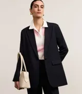 Blazer oversized de corte sastre con raya de tiza, confeccionado en poliéster y viscosa certificada, con cierre delantero sencillo.