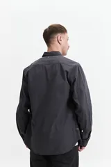 Camisa de manga larga gris oscuro, corte slim, con cartera abotonada, dos bolsillos frontales con botón y confeccionada en 100% algodón.