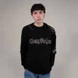 Sweater negro de lana acrílica gruesa con roturas y estampa frontal con tipografía gótica.