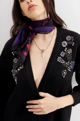 Cardigan negro de tejido de punto con ochos y terminaciones en punto rib. Presenta calce relajado, mangas largas y apliques bordados en piedras y canutillos en la parte superior del frente.