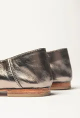 Chatas color beige de cuero vacuno, con talón suave y capellada metalizada.