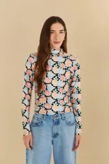 Top de cuello alto y mangas largas con estampado floral multicolor sobre fondo negro.