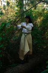 Falda midi color beige con terminación marrón, de corte envolvente y ajuste con broches metálicos.