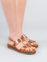 Sandalia con plataforma baja, tiras con estampado de piel de serpiente y detalles metálicos.