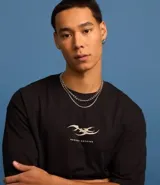 Remera negra de corte relajado, confeccionada en algodón más sostenible, con cuello redondo, manga corta y estampa frontal con un diseño abstracto y la frase "Regret Nothing".